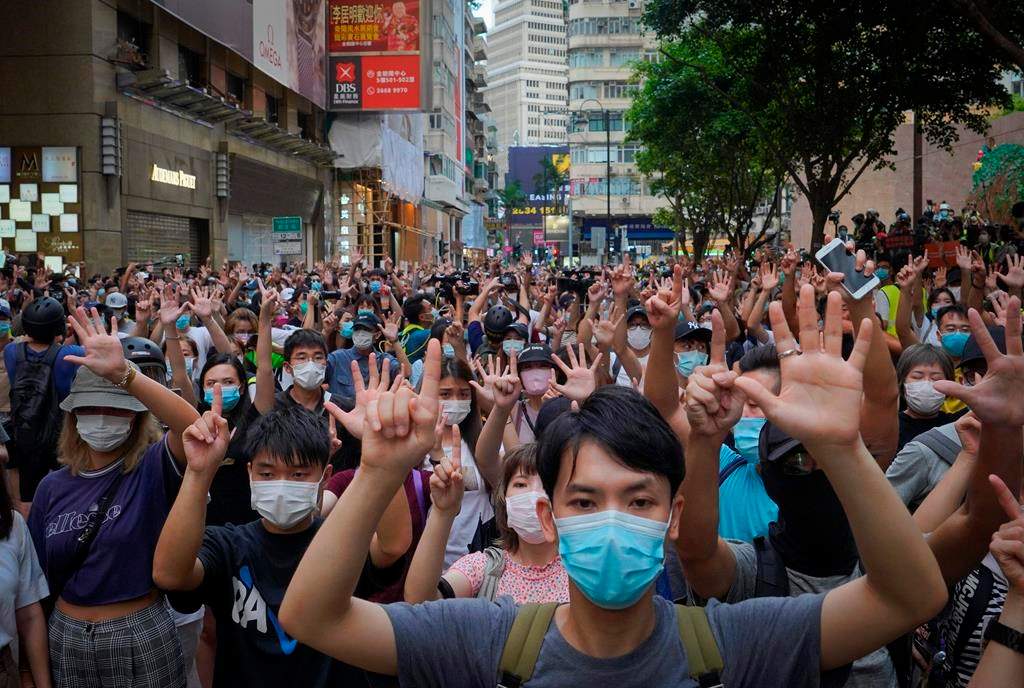 In this July 1, 2020, file photo, protesters against the new national security law gesture with five fingers, signifying the ‘Five demands — not one less’ on the anniversary of Hong Kong’s handover to China from Britain in Hong Kong. (AP Photo/Vincent Yu, file)