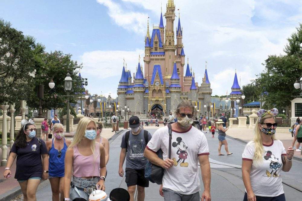 Guests wear masks as required to attend the official reopening day of the Magic Kingdom at Walt Disney World in Lake Buena Vista, Fla., Saturday, July 11, 2020.