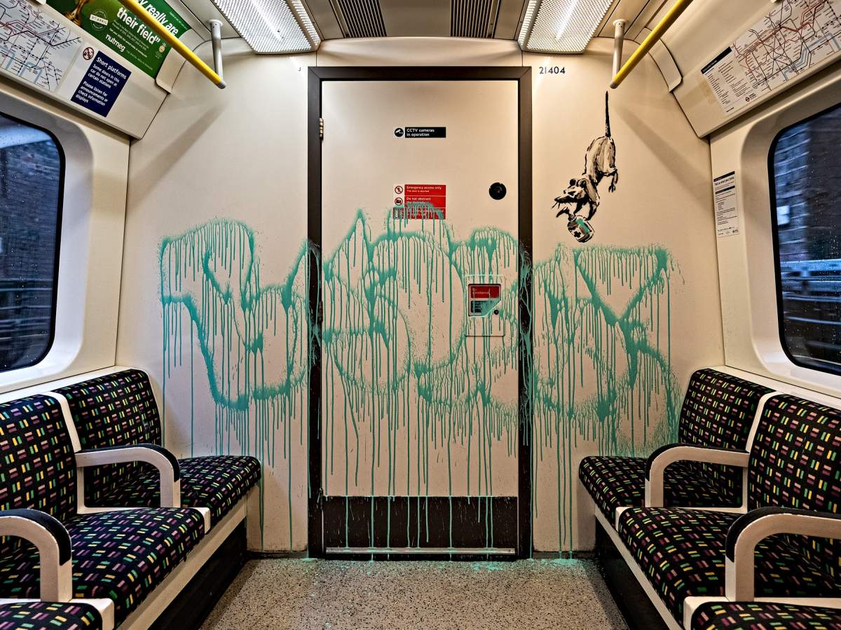 This undated photo issued on Tuesday July 14, 2020 by JBPR, shows Banksy's latest work sprayed on the inside of a London Underground tube carriage. Enigmatic graffiti artist Banksy uploaded a video to social media on Tuesday of what appeared to be him in disguise as a professional cleaner spray painting images of rats on the inside of a London Underground train along with messages about spreading the novel coronavirus.