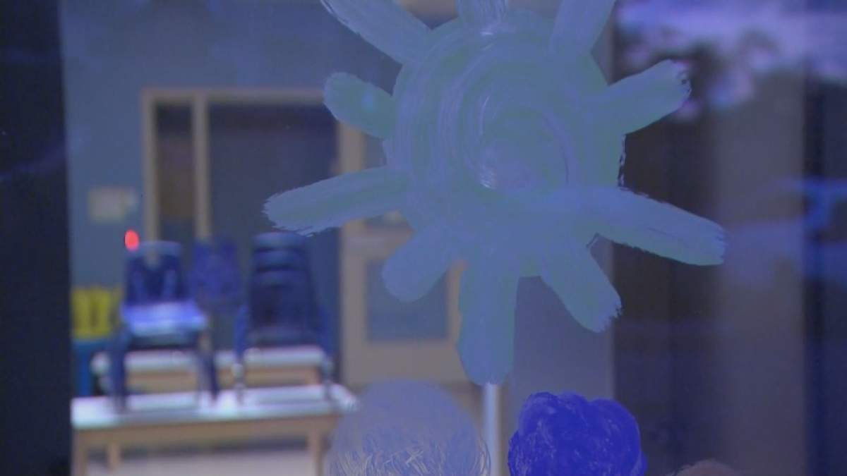 The window of the Ateliers Ateliers de Charlot l’Escargot in Boucherville, Que., which has been the site of a COVID-19 outbreak.