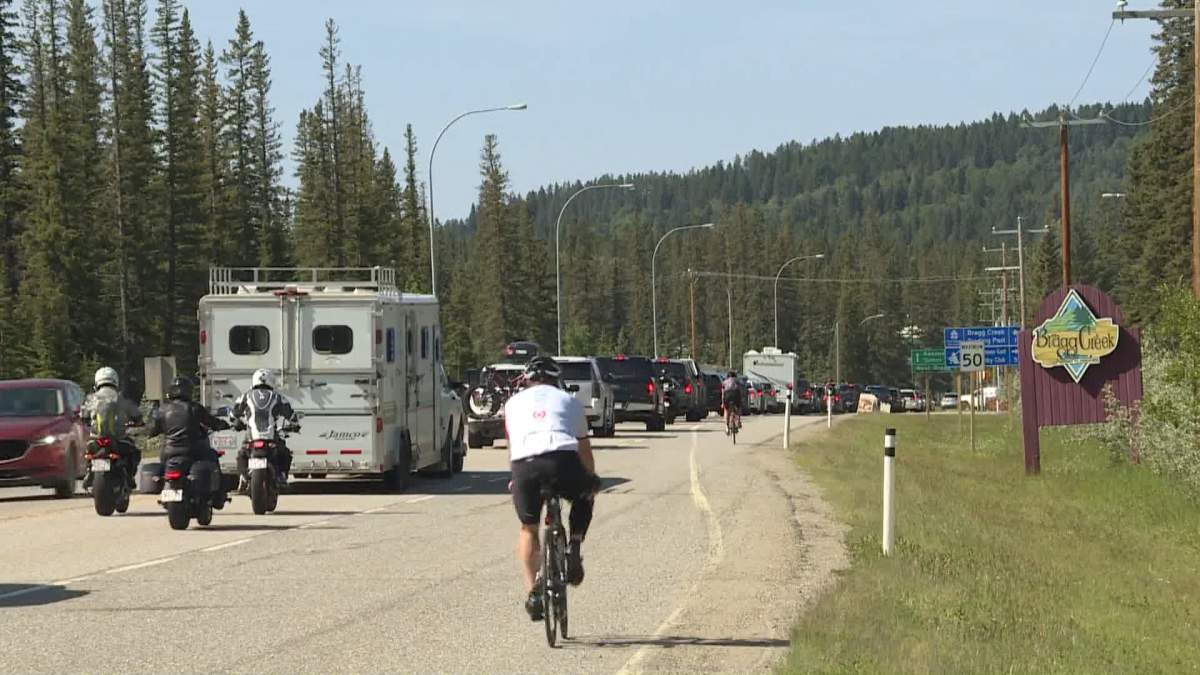 Vehicles line up to use the four-way stop in Bragg Creek, Alta., on Sunday, July 12, 2020.