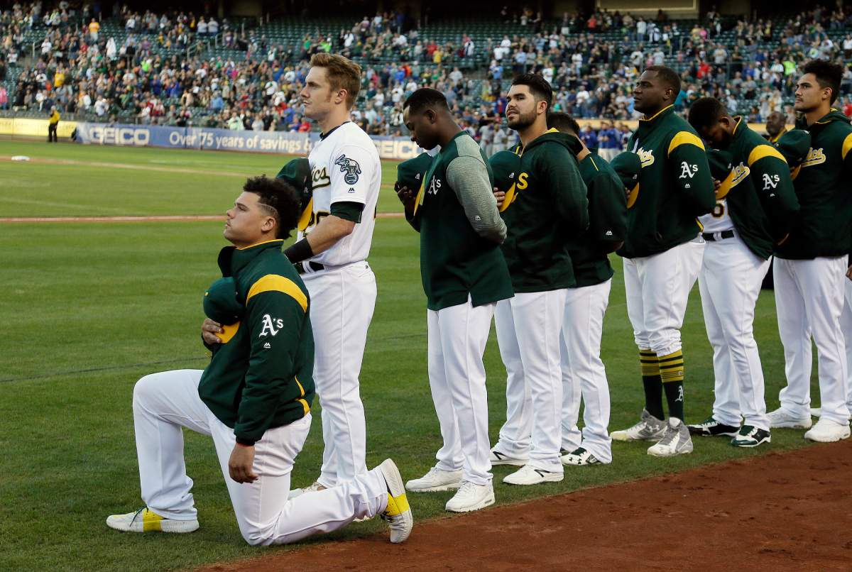 In this Sept. 23, 2017, file photo, Oakland Athletics catcher Bruce Maxwell kneels during the national anthem before the team’s baseball game against the Texas Rangers in Oakland, Calif. Maxwell is the only major leaguer to take a knee during the playing of “The Star-Spangled Banner” before a game.