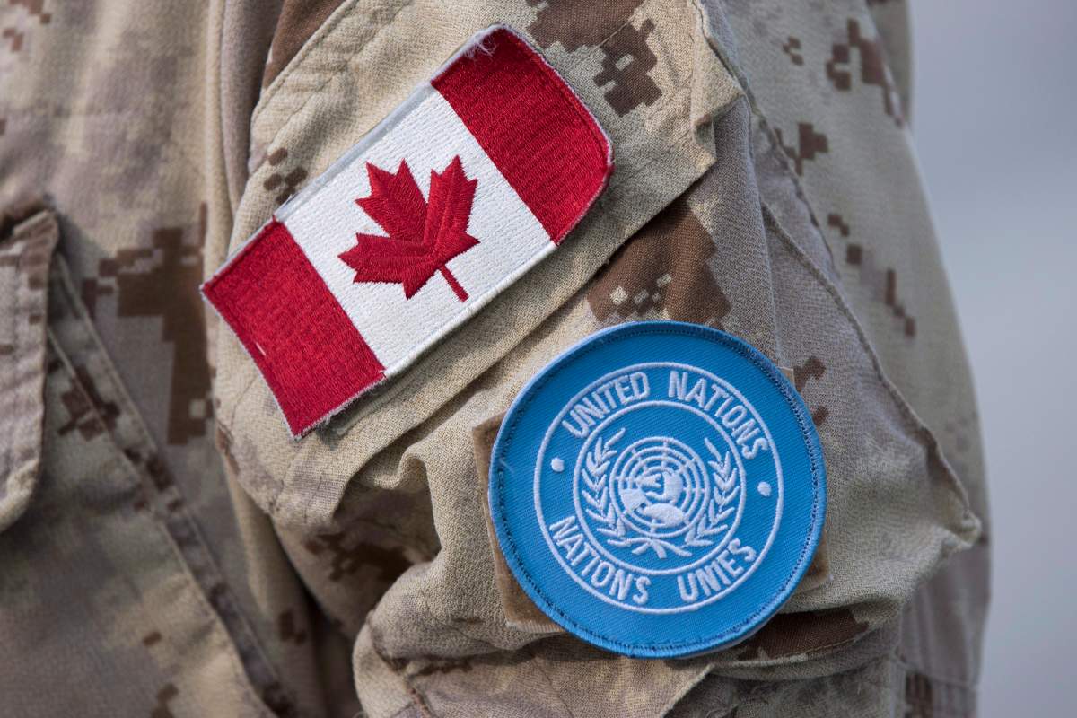 Canadian flag and the UN flag is shown on the sleeve of a Canadian soldier's uniform before boarding a plane at CFB Trenton in Trenton, Ont., on July 5, 2018. 
