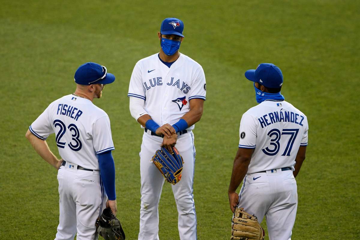 Toronto Blue Jays outfielders Derek Fisher (23), Lourdes Gurriel Jr., center, and Teoscar Hernandez (37) talk during a pitching change during the seventh inning of a baseball game against the Washington Nationals, Wednesday, July 29, 2020, in Washington.