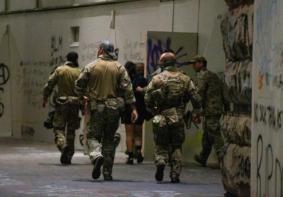 FILE - In this July 10, 2020, file photo, federal officers pull a protester into the Federal Courthouse, as protesters gather in downtown Portland, Ore.