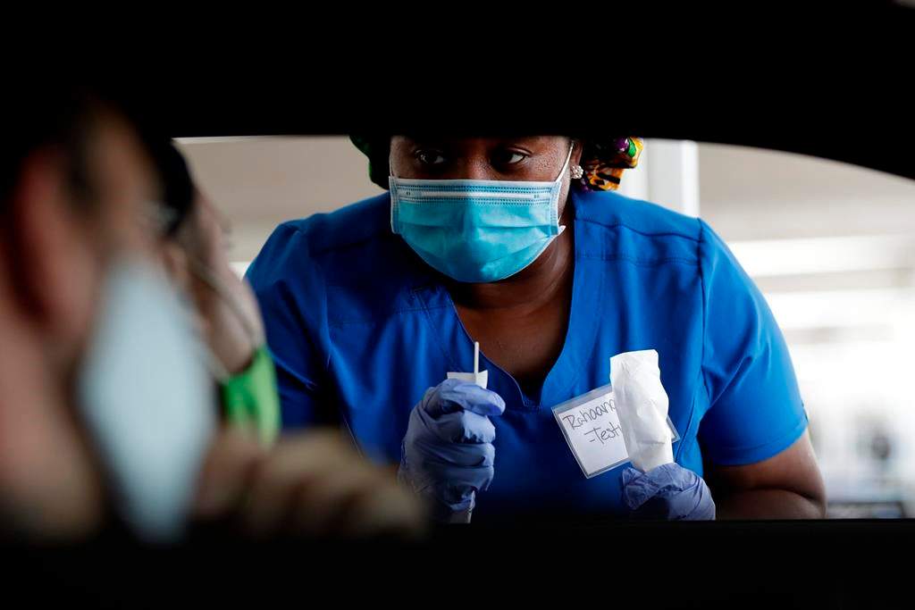Healthcare worker Rahaana Smith instructs passengers how to use a nasal swab.