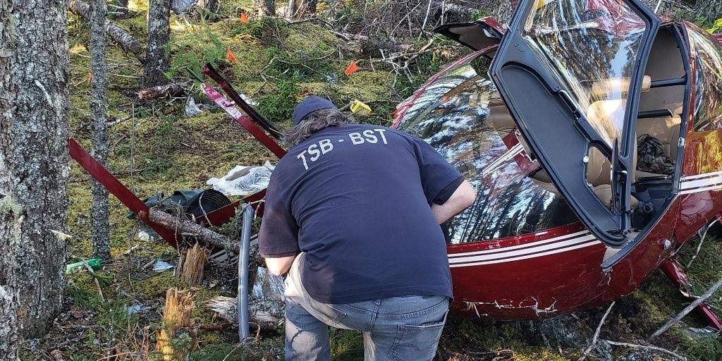 Members of the Transportation Safety Board of Canada have completed their work at the scene of a fatal helicopter crash in Newfoundland and Labrador. A TSB investigator examines wreckage of a Robinson R44 helicopter which crashed near Thorburn Lake, N.L., in an undated handout photo. One man was killed and two others sent to hospital as a result of the crash. THE CANADIAN PRESS/HO-TSB, *MANDATORY CREDIT*.