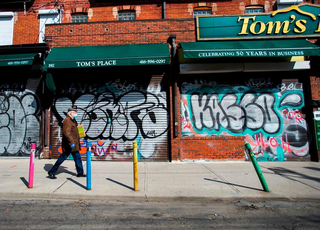 Small businesses are boarded up along an empty street in Kensington Market in Toronto amid COVID-19 lockdowns.