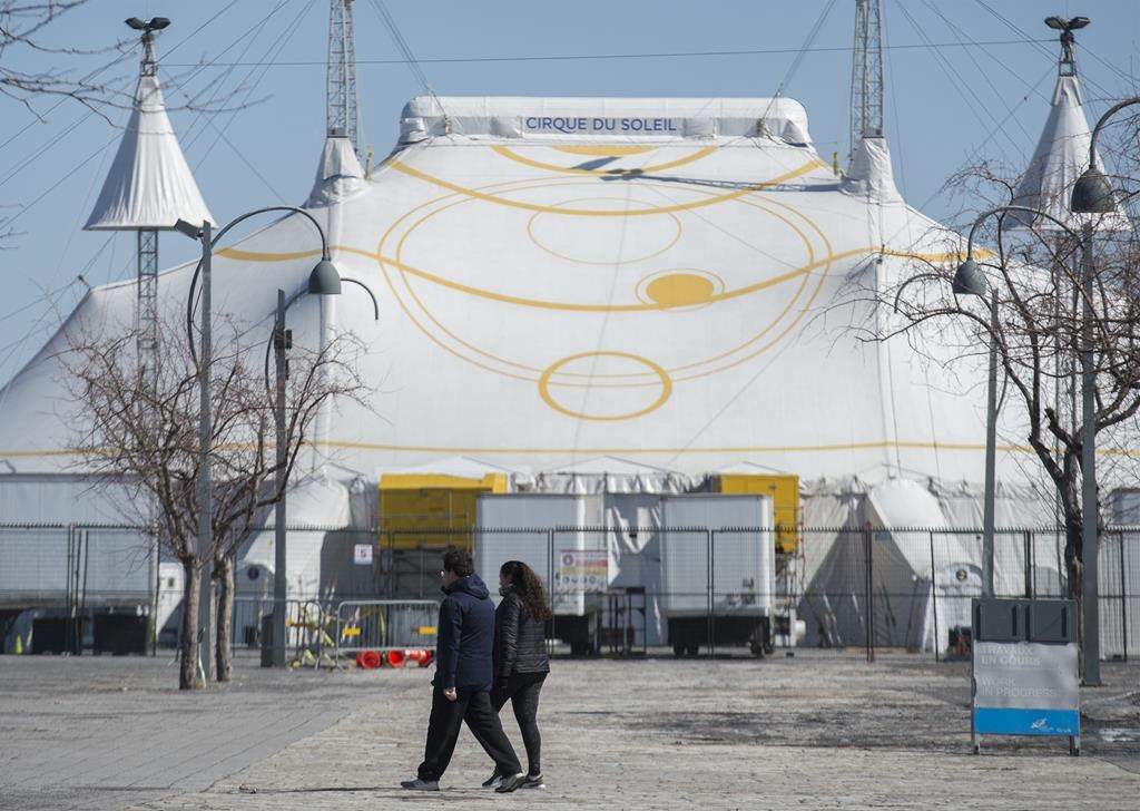 A man and woman walk by the Cirque du Soleil Big Top in Montreal's Old Port, Saturday, March 21, 2020.