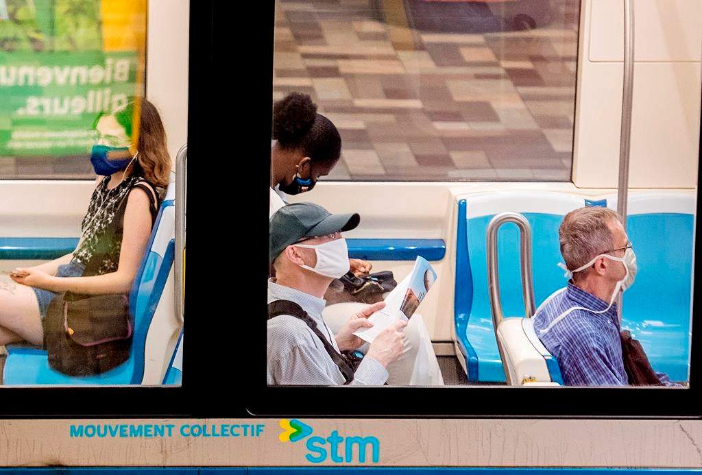 People wear face masks as they commute on a metro in Montreal, Sunday, July 12, 2020.