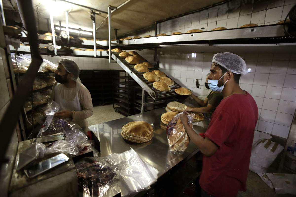Bakery workers package freshly-produced bread coming off a production line at an automated bakery in Lebanon’s capital Beirut on July 1, 2020. (Photo by JOSEPH EID/AFP via Getty Images)