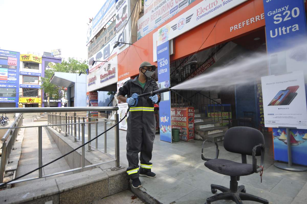 NOIDA, INDIA - AUGUST 1: A fire brigade personnel chemically disinfects the mobile market premises, at Sector 18 during the weekend lockdown imposed by the state government, on August 1, 2020 in Noida, India.