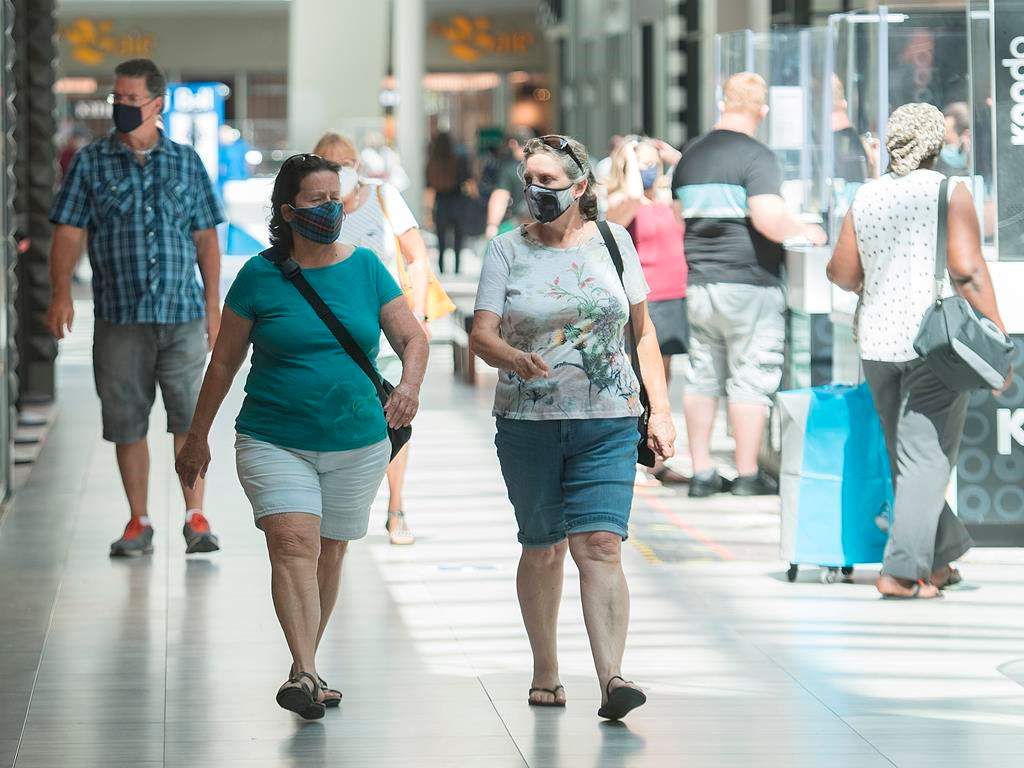 People wear face masks as they walk through a shopping mall in Montreal, Saturday, July 18, 2020, as the COVID-19 pandemic continues in Canada and around the world. The wearing of masks or protective face coverings is mandatory in Quebec as of today. THE CANADIAN PRESS/Graham Hughes.
