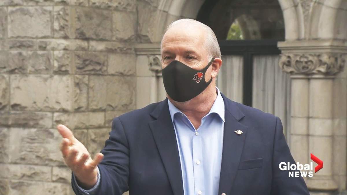 BC NDP leader John Horgan showing how he wears a BC Lions mask during a Global BC Facebook Live.