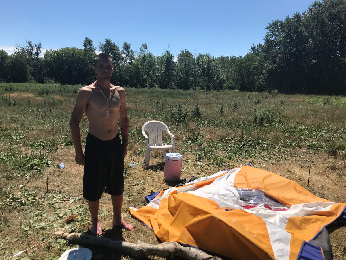 Kyle Loyst stands by his tent, which he said was damaged in the rush to remove it from Belle Park after receiving an eviction notice from the city.