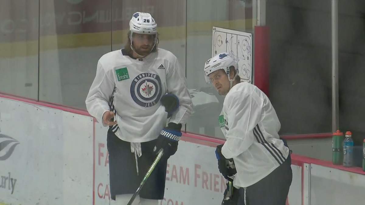 Winnipeg Jets captain Blake Wheeler talks with Mark Scheifele during a practice.