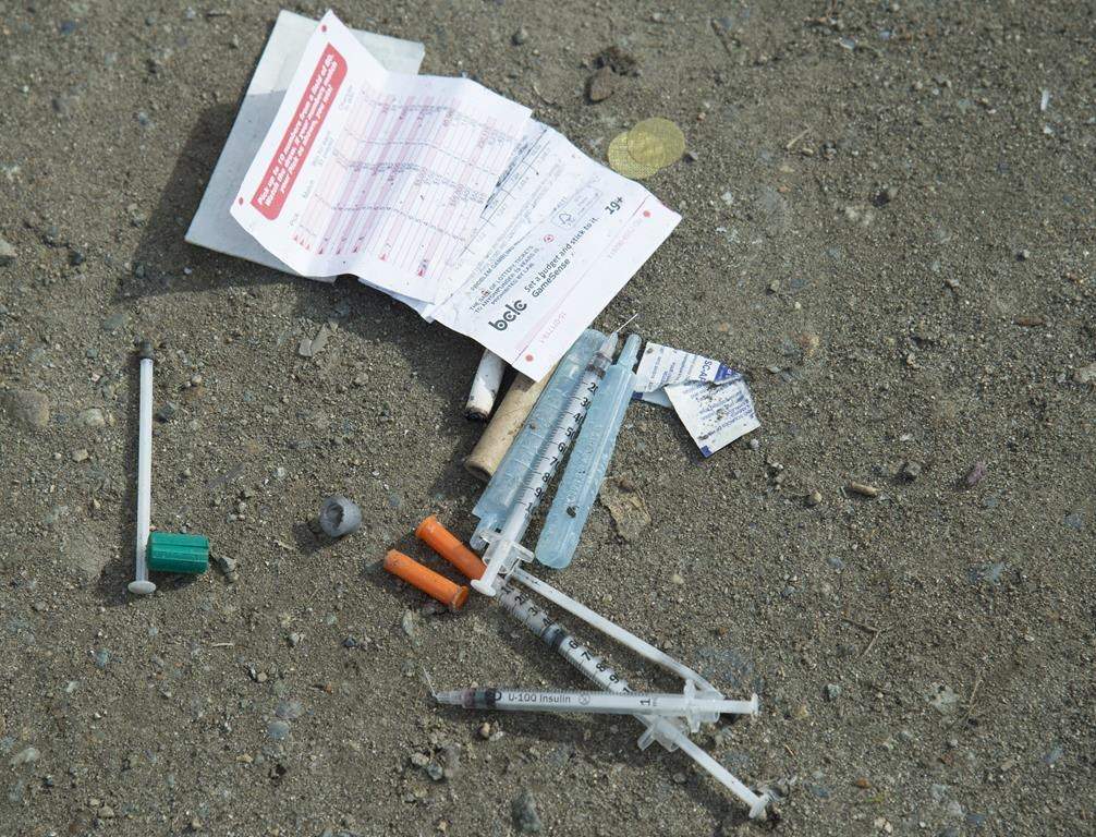 Needles are seen on the ground in Oppenheimer park in Vancouver's downtown eastside on March 17, 2020. Indigenous and civil liberties groups say the British Columbia government failed to consult them before proposing legislation that would force youth under 19 to stay in hospital after an overdose. THE CANADIAN PRESS/Jonathan Hayward.