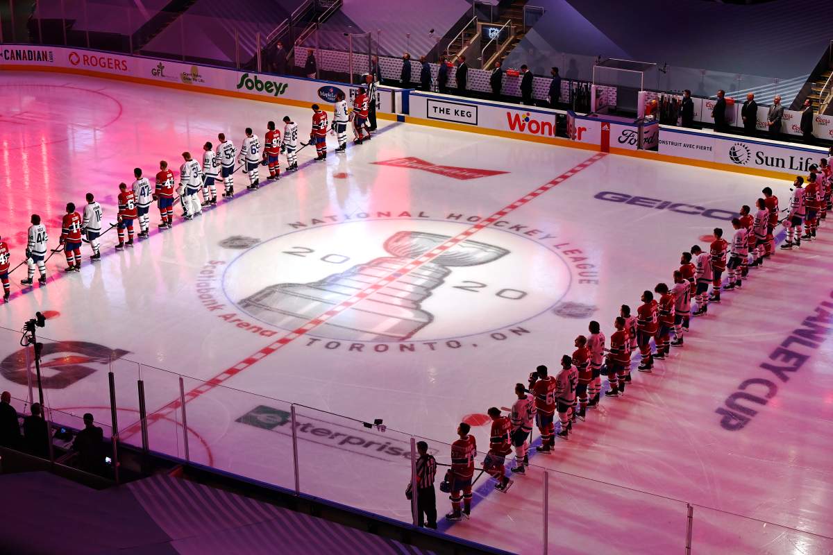 Toronto Maple Leafs and Montreal Canadiens players stand for the Canadian national anthem prior to their NHL exhibition hockey game ahead of the Stanley Cup playoff qualifiers in Toronto on Tuesday, July 28, 2020.