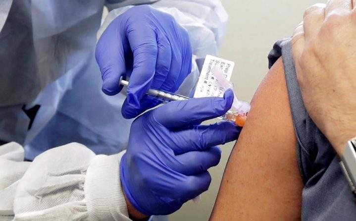 FILE - In this March 16, 2020, file photo, a subject receives a shot in the first-stage safety study clinical trial of a potential vaccine by Moderna for COVID-19, the disease caused by the new coronavirus, at the Kaiser Permanente Washington Health Research Institute in Seattle.