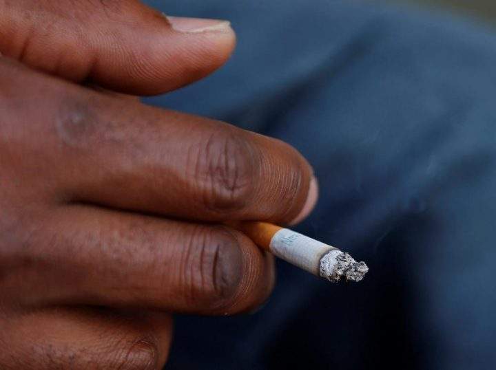 FILE - In this Sept. 17, 2015 file photo, a smoker holds his cigarette outside Oklahoma County Courthouse in Oklahoma City. 