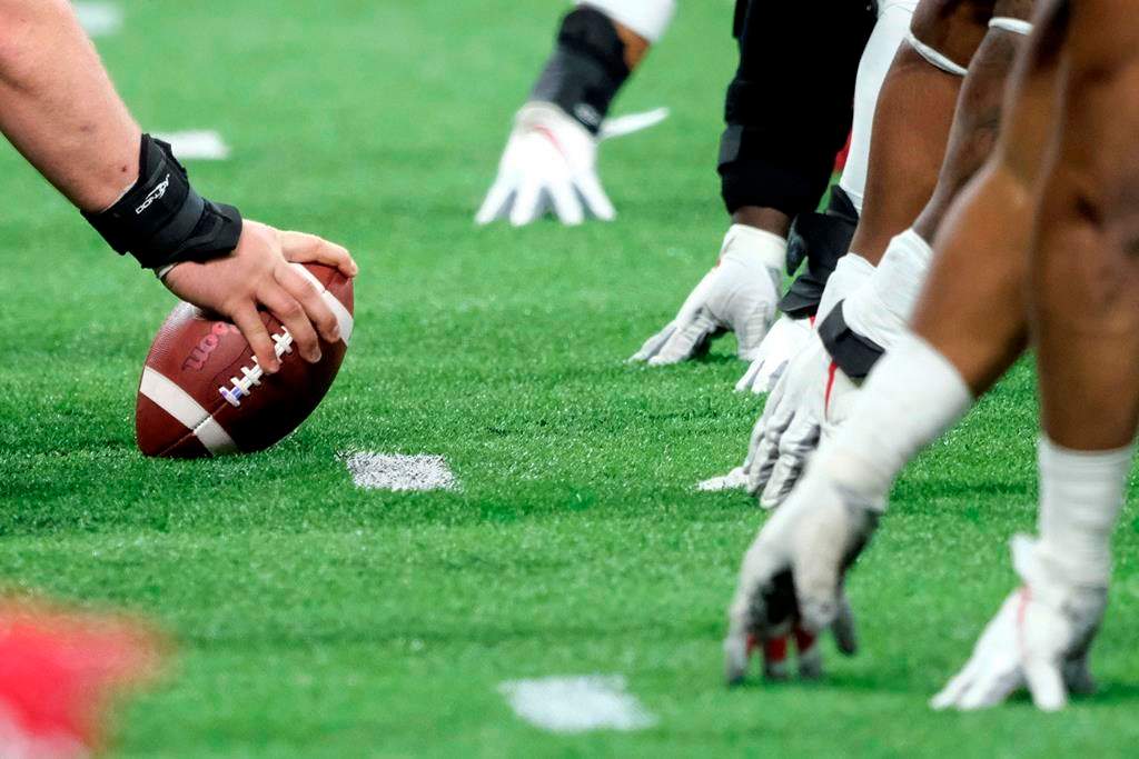 A player prepares to hike the ball at the line of scrimmage during a Big Ten championship NCAA college football game in 2019 (AP Photo/AJ Mast, File).