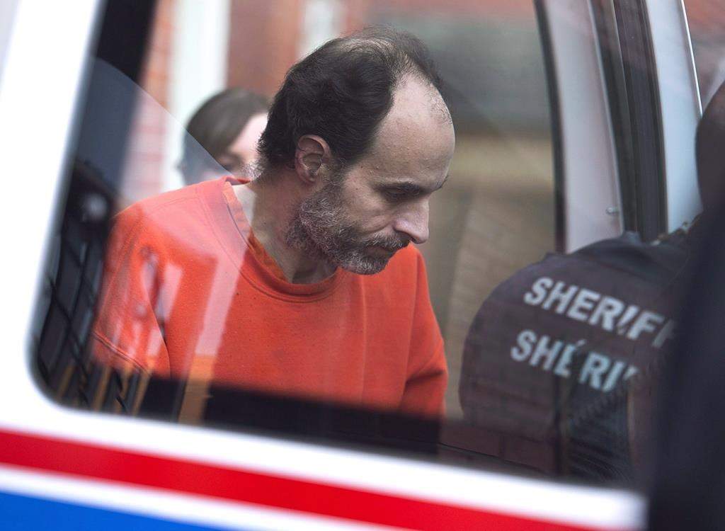 Matthew Raymond, charged with four counts of first degree murder, is taken from provincial court in Fredericton, N.B., on December 11, 2018.