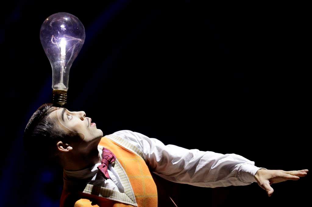A performer balances a lightbulb on his head during a preview of the Cirque Du Soleil production of "Kurios - Cabinet of Curiosities" in Sydney, Tuesday, Oct. 1, 2019.