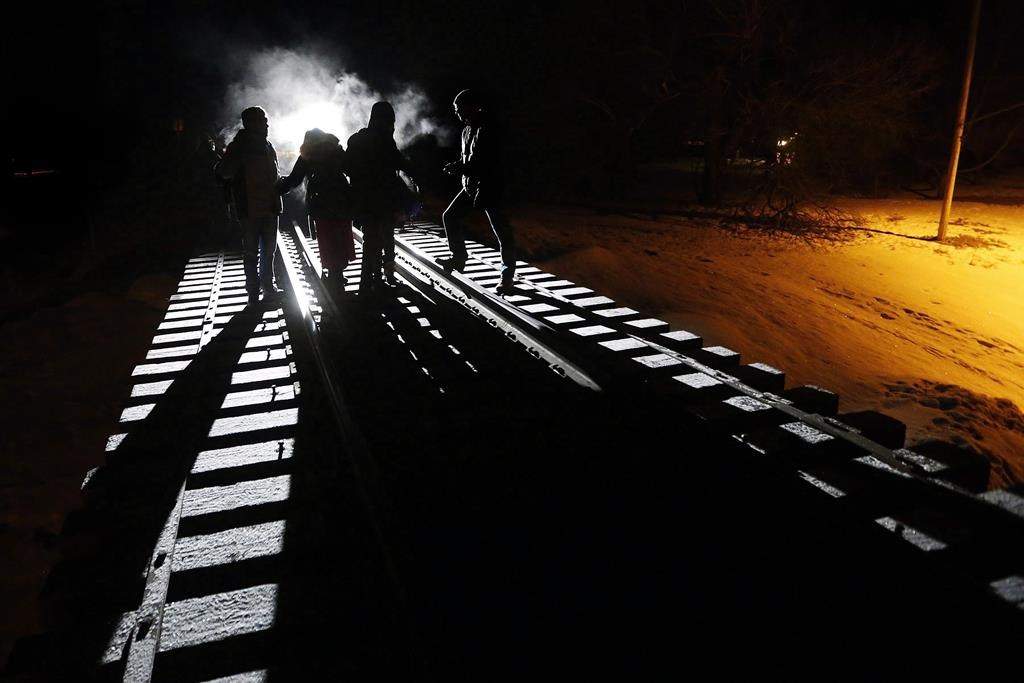 Migrants from Somalia cross into Canada illegally from the United States by walking down a train track into the town of Emerson, Man., on Feb.26, 2017. A federal judge has struck down a key agreement on refugees between Canada and the United States. In a ruling today, Federal Court Justice Ann Marie McDonald says elements of the law underpinning the Safe Third Country Agreement violate constitutional guarantees of life, liberty and security.