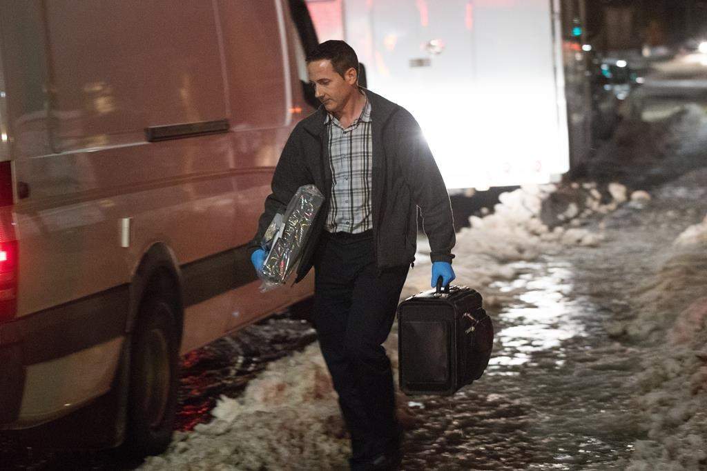 A police officer carries evidence after RCMP raided a house and arrested two people in Kingston, Ont., on Thursday Jan. 24, 2019.
