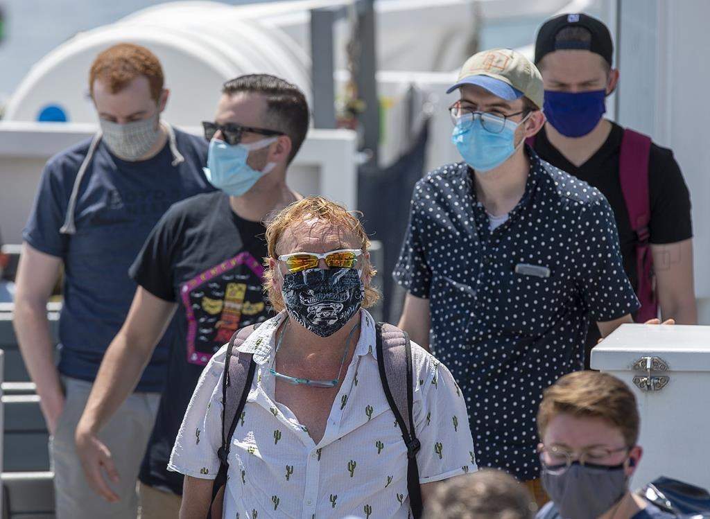 Passengers wear face masks on a Halifax Transit ferry as it arrives in Dartmouth, N.S., on Friday, July 24, 2020.