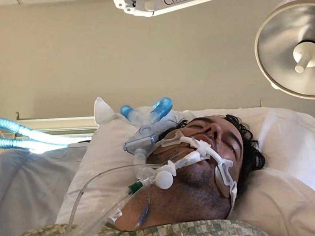 John Place breathes through a ventilator while fighting COVID-19 in an ICU bed at Westside Regional Medical Center in Plantation, Fla. Photo by Michelle Zymet