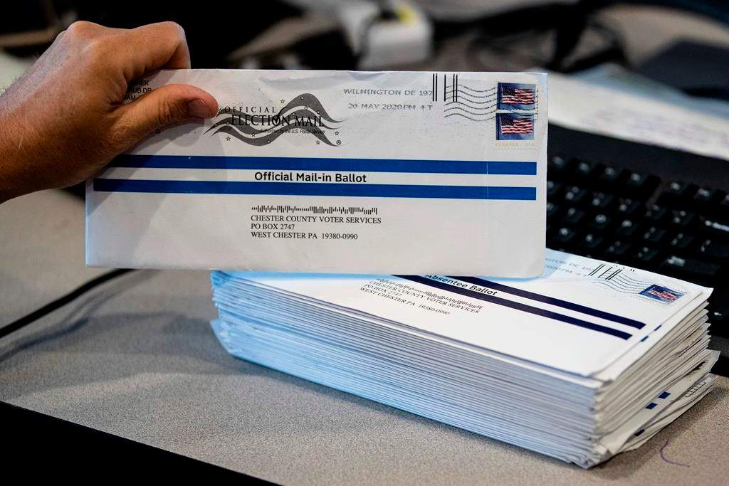 In this May 28, 2020, photo, Dave Turnier processes mail-in ballots at at the Chester County Voter Services office in West Chester, Pa., prior to the primary election. President Donald Trump’s campaign and allies have blocked efforts to expand mail-in voting, forcing an awkward confrontation with top GOP election officials promoting the opposite in their states. The rare dissonance between Trump and other Republican elected officials also reflects another reality that the president will not concede: Many in his party believe expanding mail-in voting could ultimately help him.