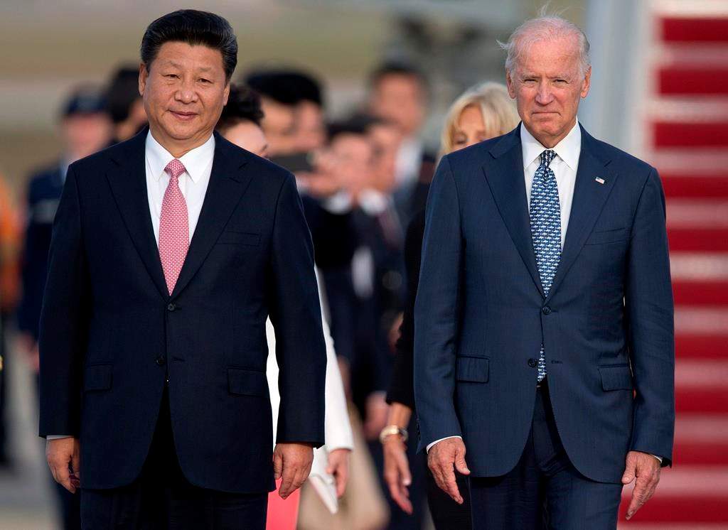 FILE – In this Sept. 24, 2015, file photo Chinese President Xi Jinping and Vice President Joe Biden walk down the red carpet on the tarmac during an arrival ceremony in Andrews Air Force Base, Md.