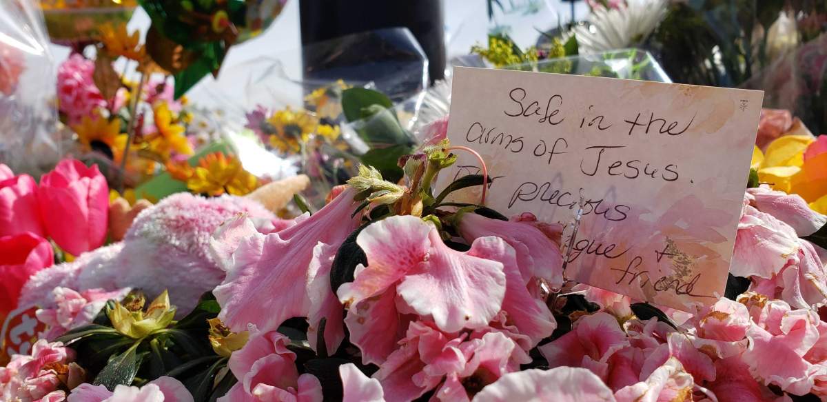 Flowers and messages are left outside the Village Mall Walk-In Clinic in Red Deer Aug. 14, 2020, to honour Dr. Walter Reynolds.