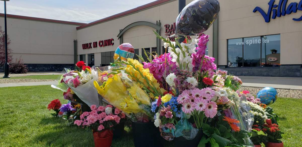 Flowers and messages are left outside the Village Mall Walk-In Clinic in Red Deer Aug. 14, 2020, to honour Dr. Walter Reynolds.