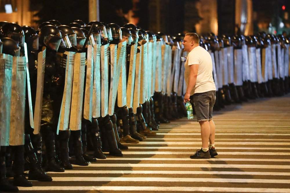 A protester speaks to police as they block the road during a rally after the Belarusian presidential election in Minsk, Belarus, Sunday, Aug. 9, 2020.