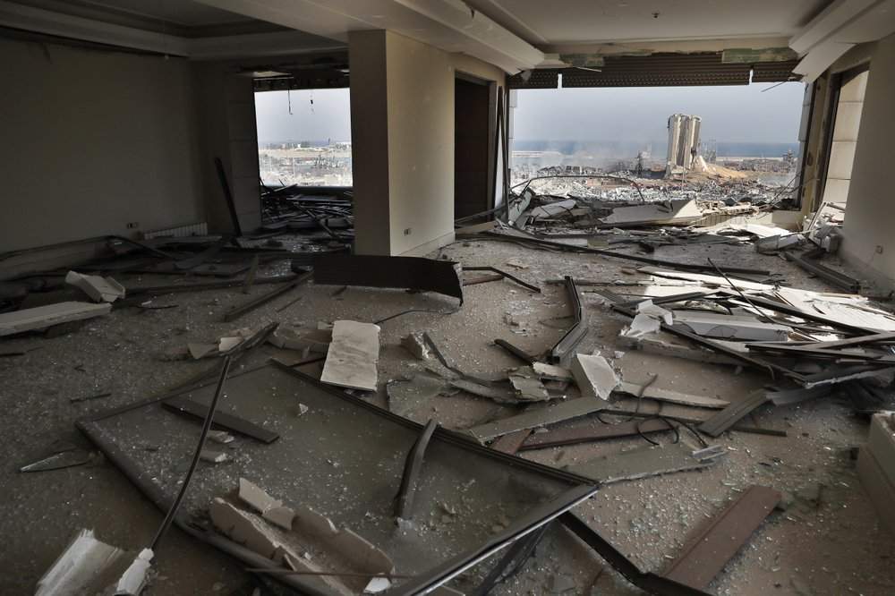 The scene of the explosion that hit the seaport of Beirut is seen through a damaged apartment in Beirut, Lebanon, Wednesday, Aug. 5, 2020. Prime Minister Hassan Diab, in a short televised speech, has appealed to all countries and friends of Lebanon to extend help to the small nation, saying: “We are witnessing a real catastrophe.”
