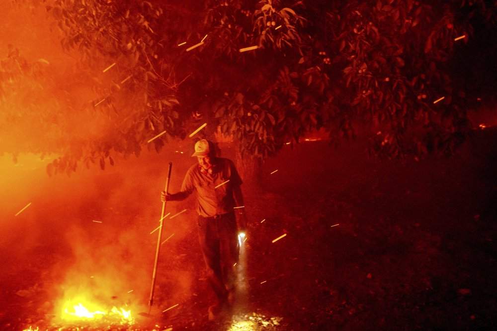Bill Nichols, 84, works to save his home as the LNU Lightning Complex fires tear through Vacaville, Calif., on Wednesday, Aug. 19, 2020. Nicols has lived in the home for 77 years.