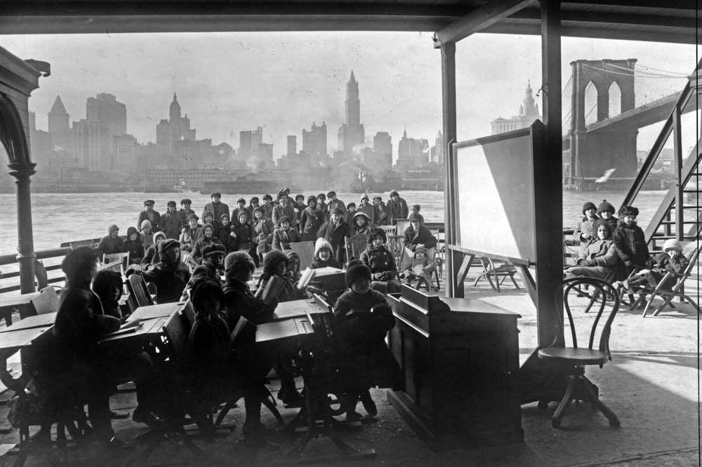 This 1911 photo from the Library of Congress shows schoolchildren on the ferry boat Rutherford, across the river from Manhattan, and near the Brooklyn Bridge, at right, in New York. Poor ventilation in school buildings across the U.S. will limit the ability of in-person instruction to resume safely. Some districts are warming to the idea of outdoor classrooms.