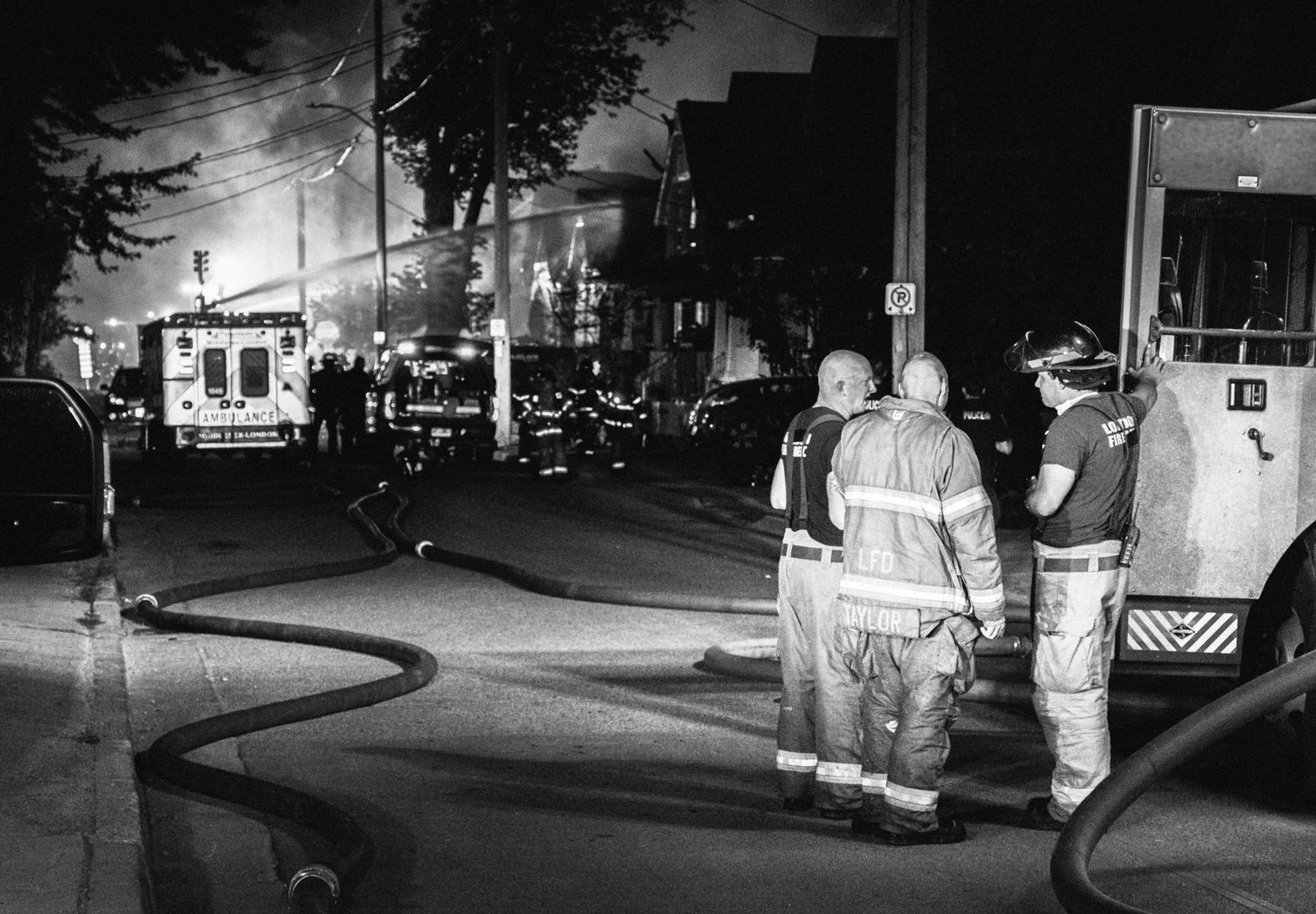 London firefighters converse near the scene of the Woodman Avenue explosion in London’s Old East Village on the early morning of Aug. 15, 2019.