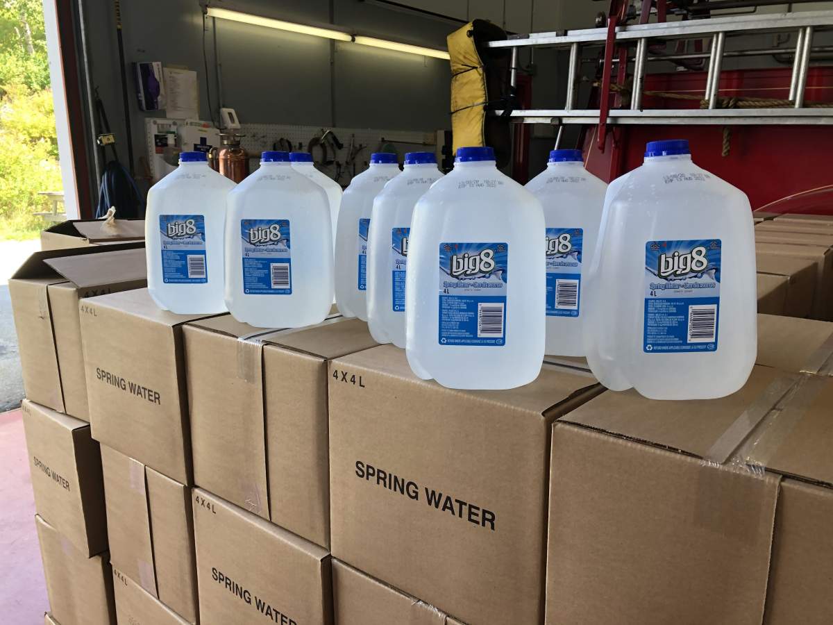 Drinking water jugs await pickup by residents in need at the fire station in Black Point, N.S. on Aug. 18, 2020.
