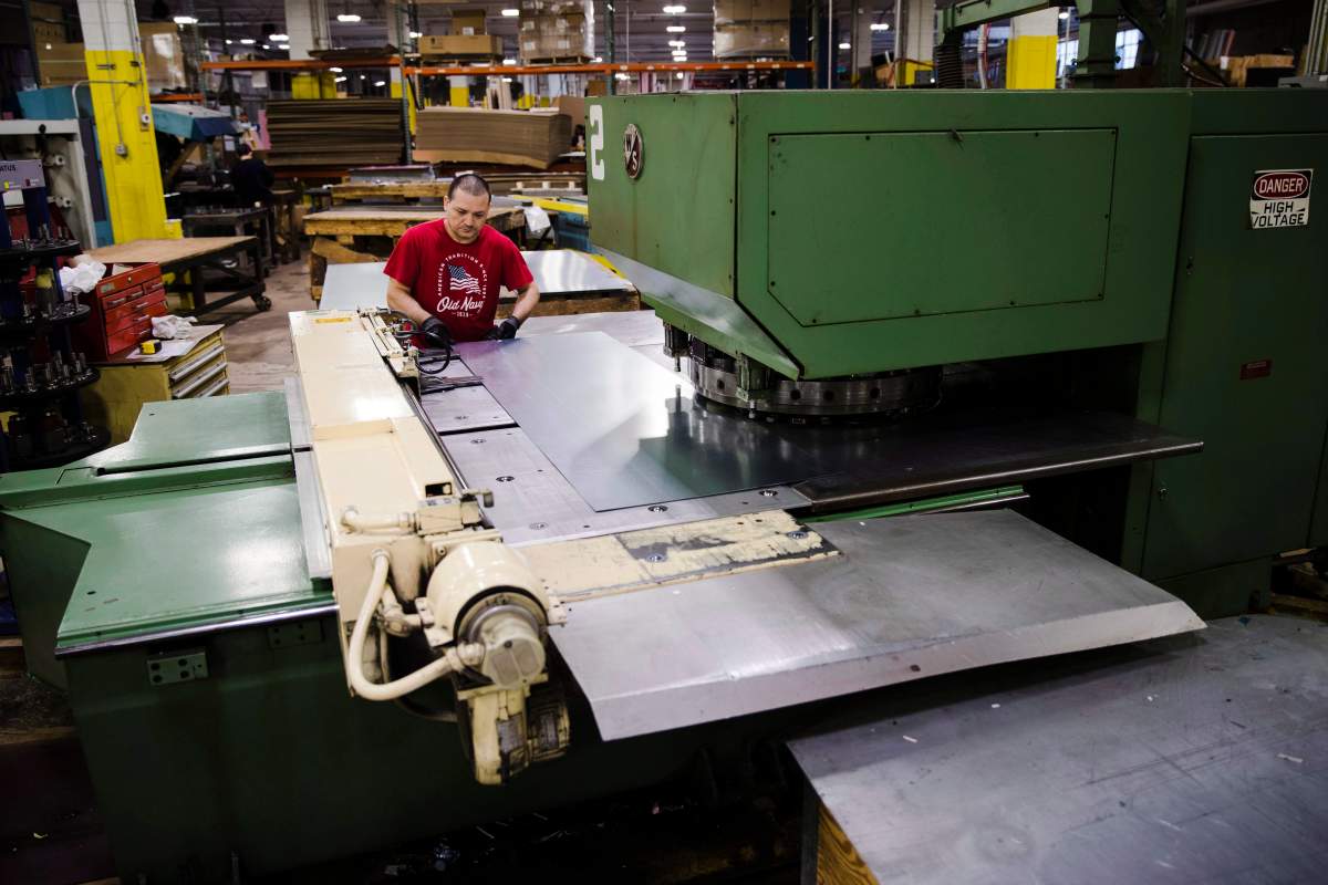 In this Thursday, Oct. 18, 2018, photo Jose Hernandez operates a turret press at the Howard McCray's commercial refrigeration manufacturing facility in Philadelphia. 