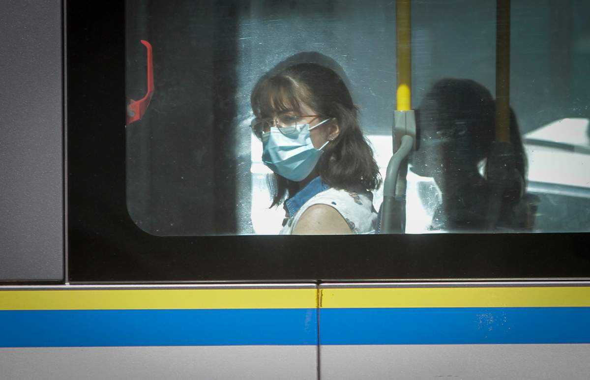 A woman wearing a face mask is seen on a bus in Vancouver, British Columbia, Canada, Aug 4, 2020. The British Columbia Provincial health officer asked the public transit authorities to implement a mandatory mask policy like some other provinces in Canada. In Regina, the city is requiring all people who are riding public transit to wear a mask. The new rules comes into effect on Friday, Aug. 21. 