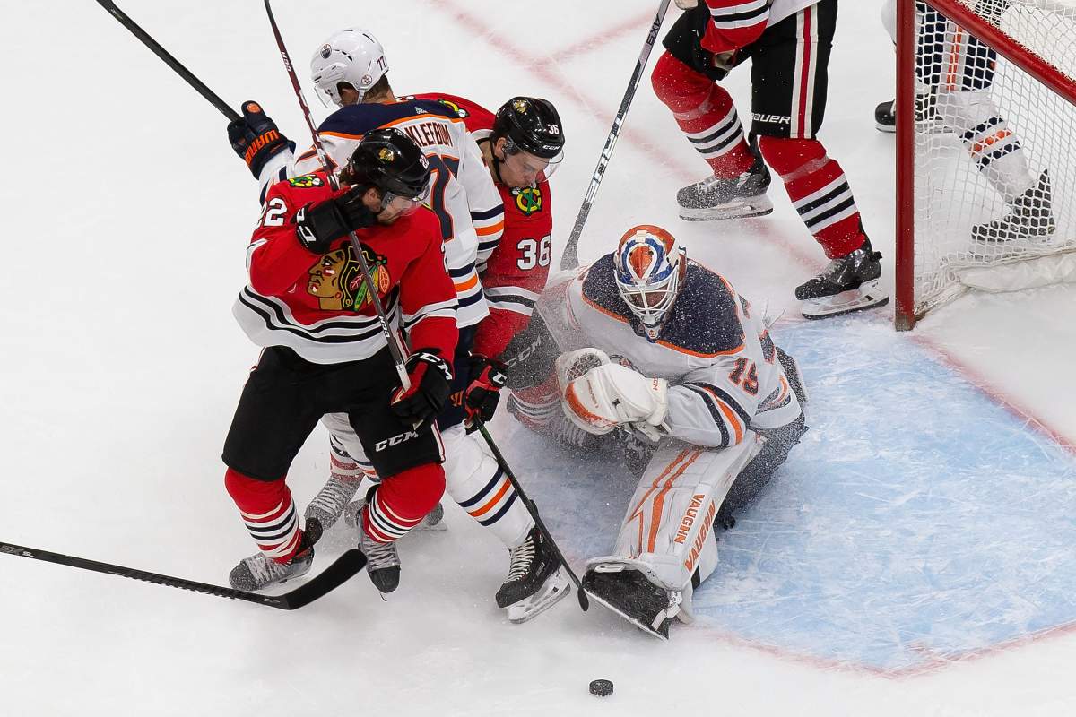 Edmonton Oilers goaltender Mikko Koskinen (19) stops Chicago Blackhawks' Ryan Carpenter (22) and Matthew Highmore (36) as Oilers' Oscar Klefbom (77) defends during second period NHL Stanley Cup qualifying round action in Edmonton, Wednesday, Aug. 5, 2020. THE CANADIAN PRESS/Codie McLachlan.