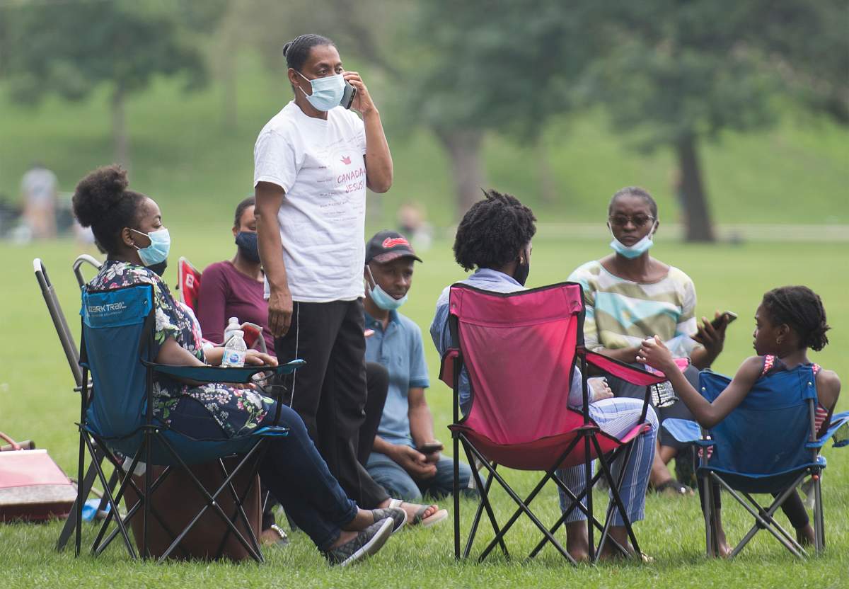 People wear face masks as they gather in a city park in Montreal, Sunday, August 9, 2020, as the COVID-19 pandemic continues in Canada and around the world. 