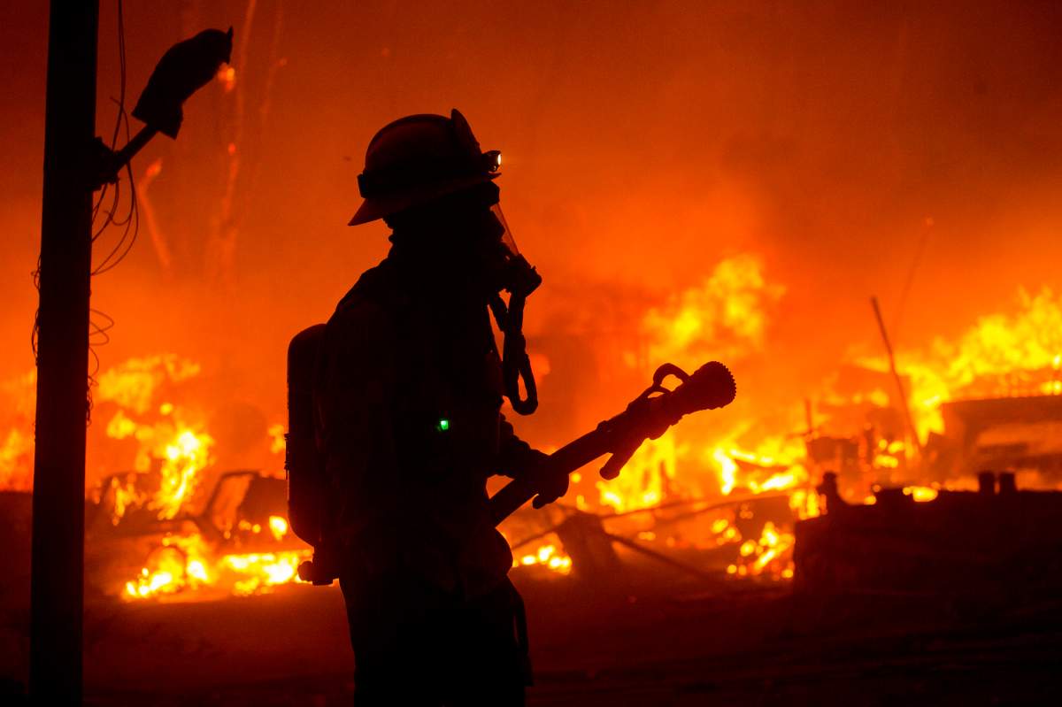 A firefighter watches the Lake Hughes fire in Angeles National Forest on Wednesday, Aug. 12, 2020, north of Santa Clarita, Calif. (AP Photo/Ringo H.W. Chiu)
