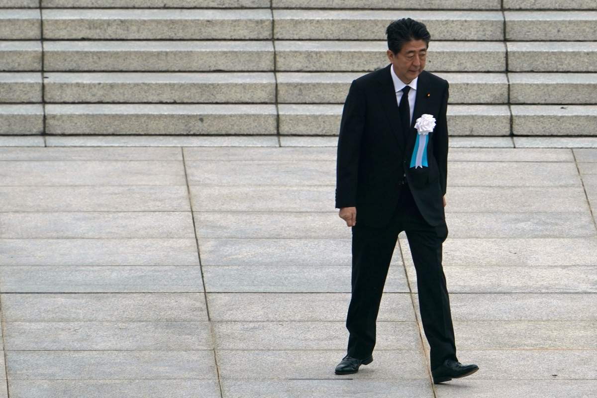 In this Aug. 6, 2020, file photo, Japanese Prime Minister Shinzo Abe walks off after delivering a speech during a ceremony to mark the 75th anniversary of the bombing at the Hiroshima Peace Memorial Park, in Hiroshima, western Japan. 