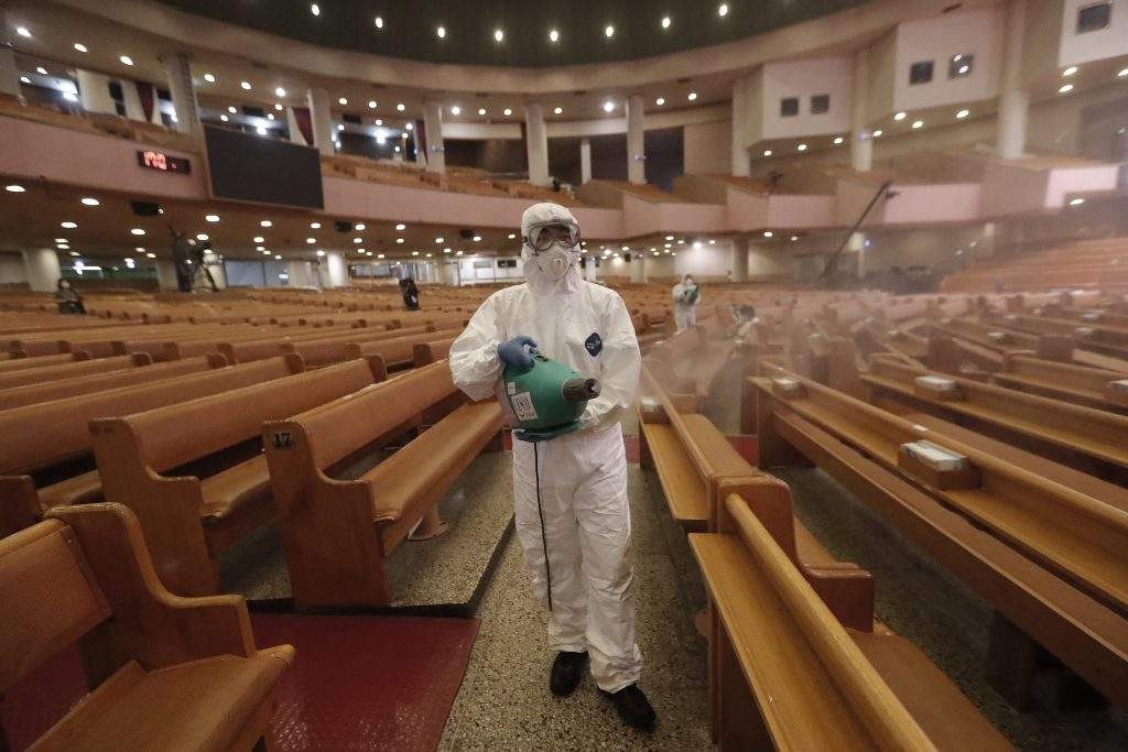 A public official disinfects as a precaution against the coronavirus at the Yoido Full Gospel Church in Seoul, South Korea, Friday, Aug. 21, 2020. South Korea's Centers for Disease Control and Prevention on Friday reported new infections from practically all major cities nationwide, including Busan, Gwangju, Daejeon, Sejong and Daegu, a southeastern city that was the epicenter of a massive outbreak in late February and March. 