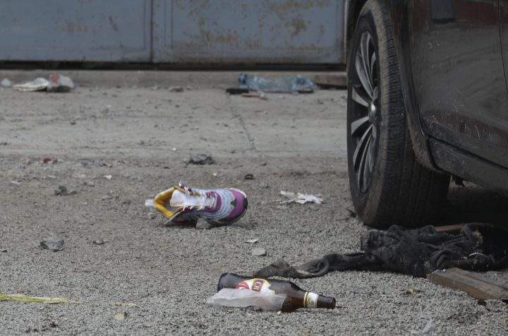 Discarded shoes and beer bottles litter the area outside the Tomas Restobar disco where officials say 13 people died in a stampede after a police raid to enforce the country's lockdown during the coronavirus pandemic, Sunday, Aug. 23, 2020. The stampede happened when about 120 people that had gathered for a party on Saturday night, tried to escape through the only door of the second-floor disco, trampling one another and becoming trapped in the confined space, according to authorities. 