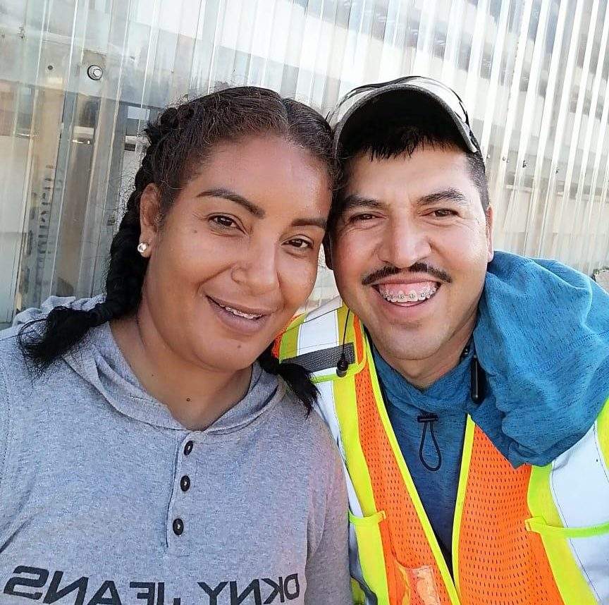 Erika Zavala (left) and Jesús Molina take a photo together at Bylands, the B.C. farm that fired them in July for inviting two people onto the property. Bylands tells Global News this violated their policy about “having visitors on site.”